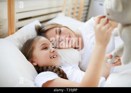 Mutter und Tochter im Bett liegend Stockfoto