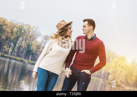 Liebe ist in der Luft. Geringer Betrachtungswinkel und der schönen Frau und ein junger Mann an jedem anderen suchen und lächelnd, während man im Freien. Junges Paar in ungezwungener Atmosphäre Stockfoto