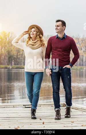 Genießen Sie unbeschwerten Spaziergang. In voller Länge von schönen jungen Paar im Freien. Wunderschöne Frau und gutaussehenden Mann weg schauen und lächeln, während Sie Stockfoto