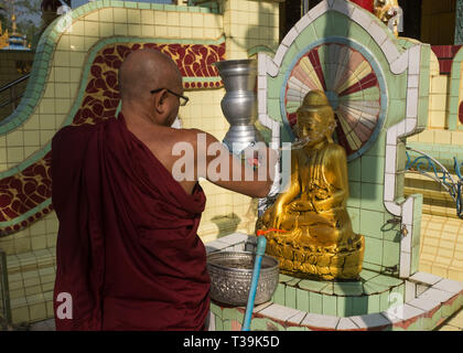 Mönch gießt Wasser auf Buddha Statue, Kaba Aye Pagoda, auch Dinkel Gaba Aye Pagoda; leuchtet. World Peace Pagoda), formell Thiri Mingala Gaba Aye Zedidaw in Stockfoto