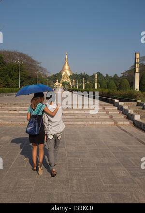 Junge paar hält einen Schirm wandern in Park & der Menschen People's Square, im Hintergrund der Shwedagon Pagode, Yangon, Myanmar (Birma) Stockfoto