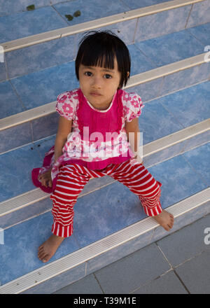 Kleines Mädchen auf einer Treppe an der Shwedagon Pagode, offiziell Shwedagon Zedi Daw genannt und auch bekannt als der große Dago Stockfoto