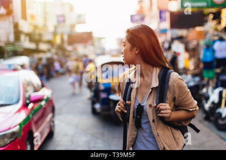 Junge asiatische Frau touristische Frau zu Fuß und mit Rucksack auf der Khaosan Road in Bangkok, Thailand. Reisen und Rucksack in Asien Konzept Stockfoto