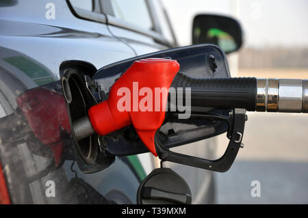 Das Fahrzeug mit Kraftstoff füllen. Tanken gun im Kraftstofftank-einfüllstutzen Stockfoto