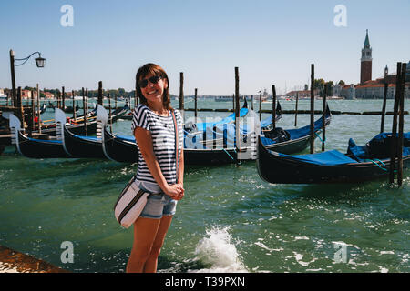 Junge Frau touristische vor der Gondeln an Traghetto Molo in der Nähe der Piazza San Marco in Venedig, Italien. Travel Concept. Stockfoto