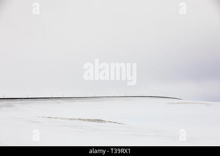 Highway 61 führt von Hólmavík West durch hohe, schneebedeckte Barrens im Winter in der Region Westfjorde Islands Stockfoto