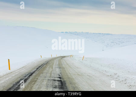 Highway 61 führt von Hólmavík West durch hohe, schneebedeckte Barrens im Winter in der Region Westfjorde Islands Stockfoto