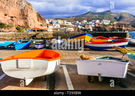 Traditionelle bunte Boote, das Meer und die Berge in Puerto de Sardina Dorf, Gran Canaria, Spanien. Stockfoto