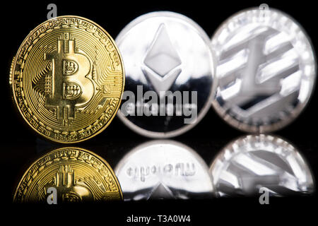 Bitcoin, Litecoin und des Astraleums" Münzen sind fotografiert cryptocurrency in einem Studio in London am 8. April 2019 dar. . Stockfoto