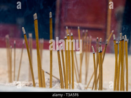 Nahaufnahme eines Altars mit Drachen, Carving, Räuchergefäß, Joss Topf, Räucherstäbchen brennen mit raucht in einem buddhistischen Tempel. Stockfoto