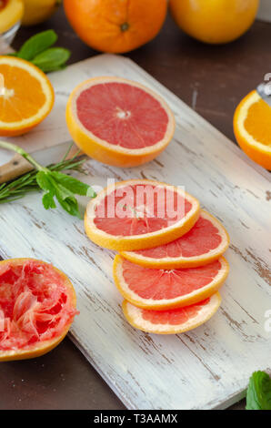 Reife Grapefruits und Orangen auf dem hölzernen Tisch, Stockfoto