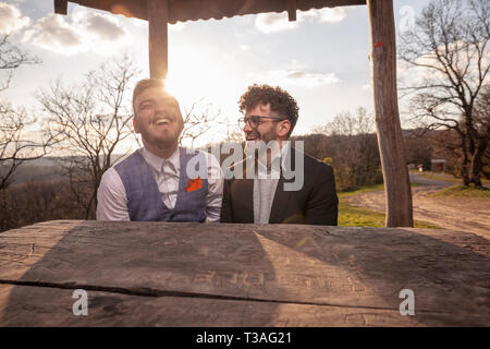 Zwei Männer, ein schwules Paar Interaktion lachen Portrait. obere Körper geschossen. sitzen zusammen am Tisch im Freien, im Nationalpark Fruška Gora", Serbien. Stockfoto