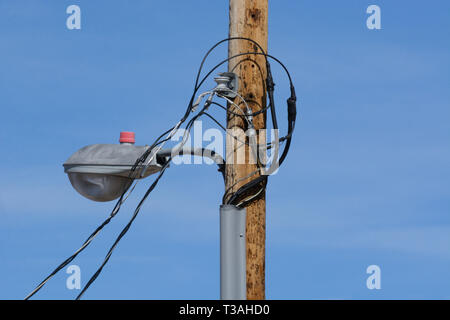 Neue städtische Straßenlaterne auf neue hölzerne Stange mit neuen temporären power line Kabel angeschlossen, aber noch nicht vollständig installiert Stockfoto