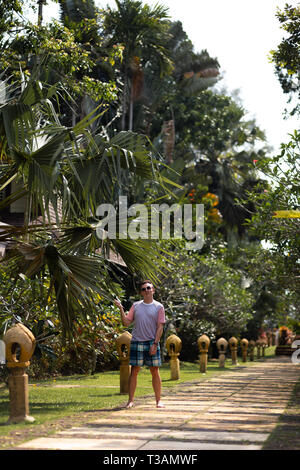 Junger Mann travaler Wandern in einer Palm Park auf Ko Chang, Thailand im April 2018 - Am besten Reiseziel für Glück überhaupt Stockfoto