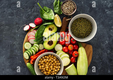 Zutaten zum Kochen vegetarisches Essen. Vielzahl rohes Gemüse und Getreide Draufsicht auf dunklem Stein Hintergrund Stockfoto