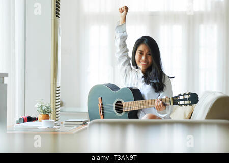 Fröhliche Frau Gitarre spielen Stockfoto