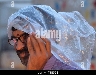 Bangalore, Indien. 8 Apr, 2019. Ein Mann ist in der Regen in Bangalore, Indien, April 8, 2019 gesehen. Der Regen hat die Temperaturen auf, denn das Wetter war heißer in Bangalore City bringen. Credit: Stringer/Xinhua/Alamy leben Nachrichten Stockfoto