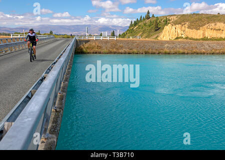 Radfahrer Überqueren eines Kanals zwischen Rotorua und Lake Ohau auf die Alpen 2 Ocean Cycle Trail Stockfoto