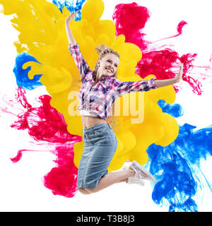 Glückliche Frau springt über Farben explosion Hintergrund. Stockfoto