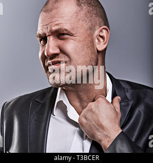 Unglücklich betonte Kahlen wütend Geschäftsmann ziehen der Hemdkragen mit sehr schlechten Emotionen in Bürosoftware auf Grau studio Hintergrund. Closeup Portrait Stockfoto