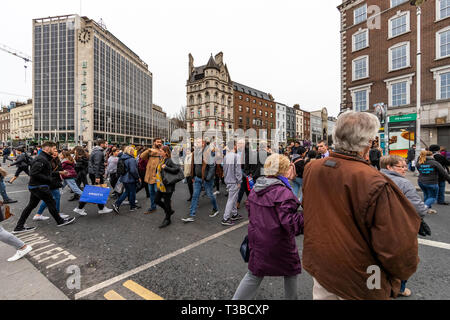 Menschenmassen in der Innenstadt Kreuz an einer Kreuzung überqueren. Dublin, Irland Stockfoto