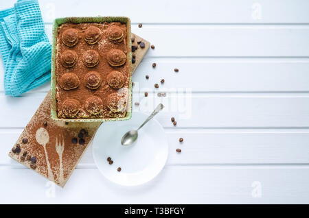Fach mit Tiramisu Dessert mit Schokolade auf weißem Holz- Hintergrund. Ansicht von oben mit Speicherplatz zu kopieren. Stockfoto