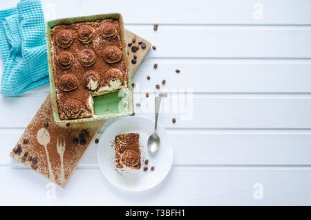 Fach mit Tiramisu Dessert mit Schokolade auf weißem Holz- Hintergrund. Ansicht von oben mit Speicherplatz zu kopieren. Stockfoto