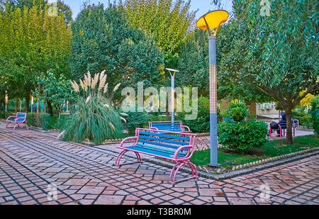 Teheran, Iran - Oktober 10, 2017: Den angenehmen Abend Spaziergang entlang der malerischen grünen Gasse von Honarmandan (Künstler) Park mit Bänken und futuristische stre Stockfoto