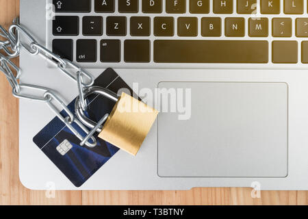Vorhängeschloss mit Kette und Kreditkarte auf einem Laptop Tastatur. Online shopping Sicherheit abstraktes Konzept. Kopieren Sie Platz auf der rechten Seite. Stockfoto