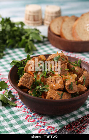 Rindergulasch ist in einem braunen Schüssel auf dem Tisch liegt Stockfoto