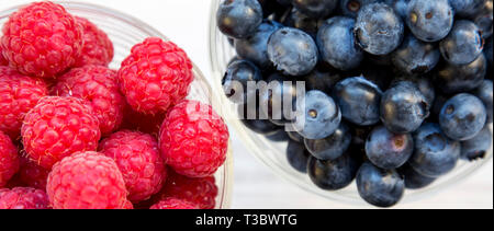 Vollen Schüsseln mit Blaubeeren und Himbeeren, Ansicht von oben. Gesunde Ernährung und Diät. Overhead, von oben. Stockfoto