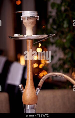 Holz- Shisha auf einem verschwommenen Hintergrund mit bokeh Close-up. Stockfoto
