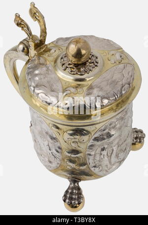 Eine silberne Bierkrug mit Deckel, Nürnberg, ca. 1660/70 Silber, teilweise vergoldet. Zylindrische Körper auf drei Krallen - und - Kugel - Füße. Drei umliegende Kartuschen mit Darstellungen von Landschaften zwischen Akanthusblättern. Klappdeckel mit Gehämmerten Darstellungen von Landschaften, den oberen Knopf in der Form einer Frucht auf einem durchbohrten dekorative Platte. Durchbohrt Daumen Hebel in der Form von Ranken. Deckel und Boden mit Mark Master's Mühle (Mühle), Nürnberg und der proofmark Il Saggiatore Zick-zack-Markierung. Höhe 18,7 cm, Gewicht 685 g. Die Mühle wurde von mehreren Mitgliedern der Mülle, Additional-Rights - Clearance-Info Not-Available verwendet. Stockfoto