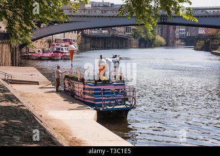 Mann Befestigung Zeichen auf dem vollen Moo Eis Boot vertäut am Ufer des Flusses Ouse in York mit Lendal Bridge im Hintergrund Stockfoto