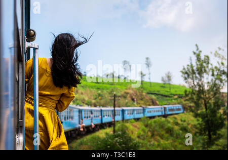 Frau genießen die Fahrt mit dem Zug durch Sri Lanka Tee Plantagen Stockfoto