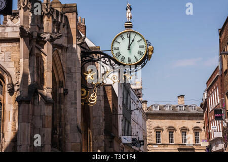 Ein Blick auf die belebte Coney-Straße im Stadtzentrum von York mit der reich verzierten hängende Wanduhr auf St. Martins Kirche Stockfoto