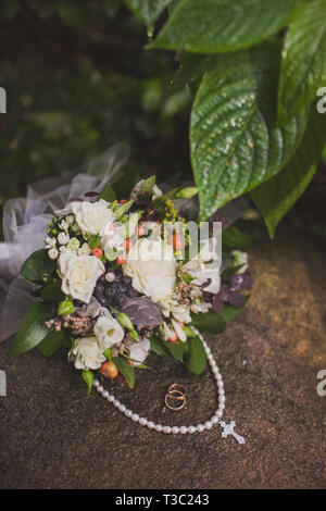 Diamantene Hochzeit Ring und Kreuzes Halskette auf Stein platziert Stockfoto