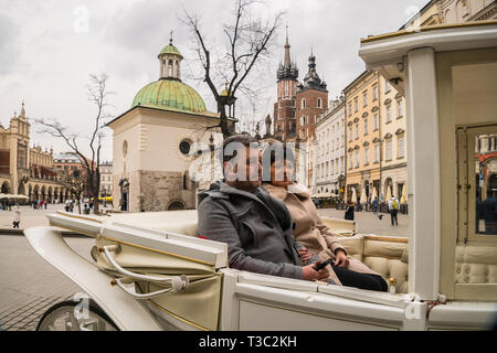 Krakau, Polen - 22. März 2019 - touristische Fahrt mit der Pferdekutsche am Hauptplatz in Krakau Stockfoto