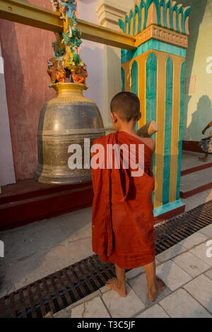 Anfänger buddhistischer Mönch Anschlagen einer Glocke Am Vesak Full Moon Festival der Geburtstag des Herrn Buddha Shwe Yin Maw Pagode, in der Nähe von Thazi, Myan zu feiern. Stockfoto