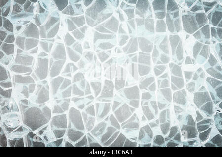 Gebrochene Glas der Windschutzscheibe Textur auf einem grauen Hintergrund. Zerbrochenes Glas mit weißen Risse. Stockfoto