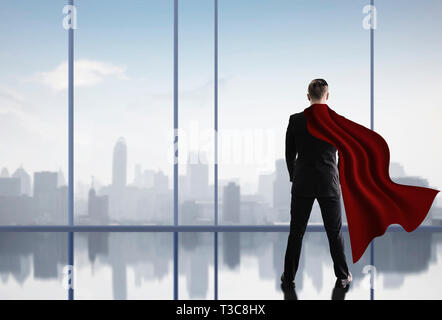 Super Hero business Mann in Anzug stehen und auf Stadtbild ansehen und denken Business Plan der Zukunft Stockfoto