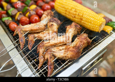 Gegrillte Chicken Wings und Gemüse vom Grill im Hinterhof Stockfoto