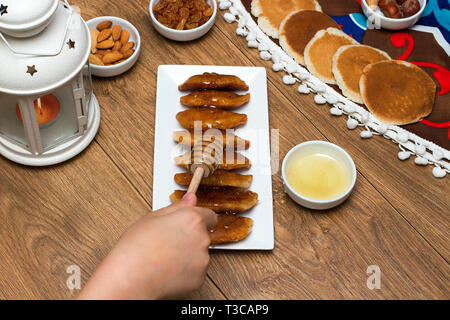 Gießen Honig auf Qatayef-traditionellen nahöstlichen Spezialitäten, die in der Regel in Muslime heiligen Monat Ramadan gegessen: Stockfoto