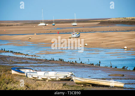 Bunte Boote marooned auf Sandbänken bei Ebbe im Osten Flotte Mündung an der Brunnen neben dem Meer, North Norfolk Coast, East Anglia, England, UK. Stockfoto