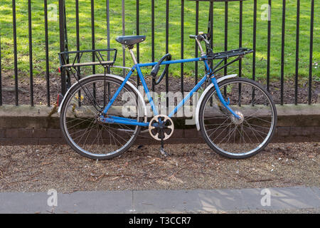 Alte blaue Fahrrad gegen Geländer in New Walk, Leicester, UK schiefen Stockfoto