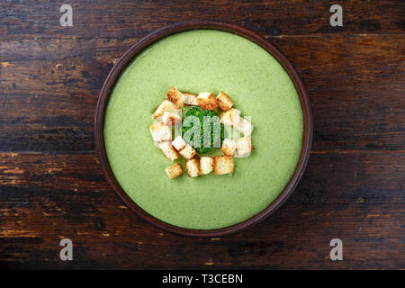 Broccoli creme Suppe in einer Platte auf einem dunklen Hintergrund. creme Suppe dekoriert Brokkoli Blütenstand. top View Stockfoto