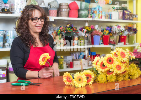 Lächelnd reife Frau Florist einen Strauß Blumen an den Blumenladen. Stockfoto