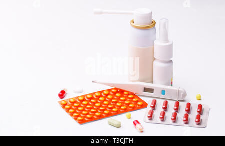 Die Behandlung der Grippe. Rachen Spray, Nasentropfen, kalte Pillen und Thermometer auf weißem Hintergrund. Stockfoto
