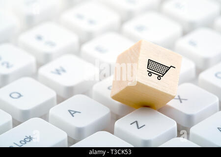 Holzblock mit Warenkorb Grafik auf PC-Tastatur. Online shopping Konzept. Stockfoto