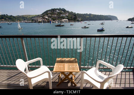 Ein Paar (männlich & weiblich), genießen Sie die Aussicht über den Fluss Dart Flussmündung zu Kingswear vom Balkon Ihres Hauses in Dartmouth, Devonshire, Großbritannien Stockfoto